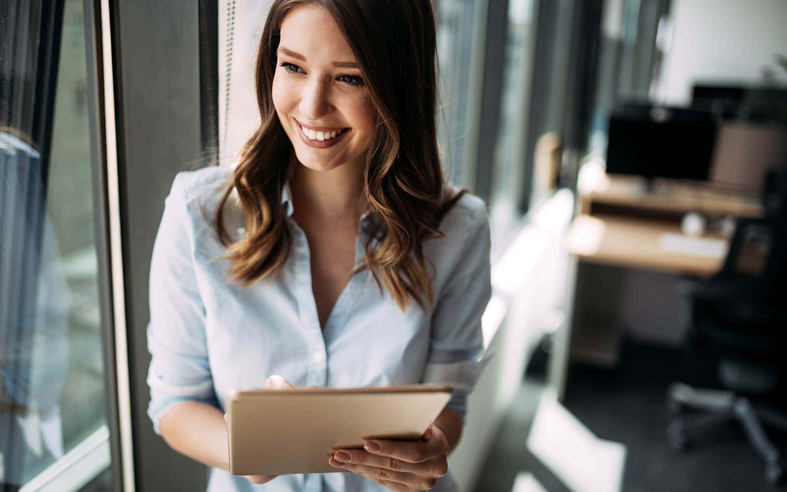 Woman standing at the window with a tablet